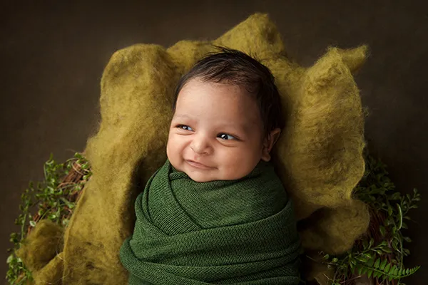 Wrapped newborn baby photographed during studio session in Auckland